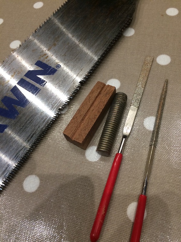 Making the bridge from a spare bit of fretboard and a bolt.