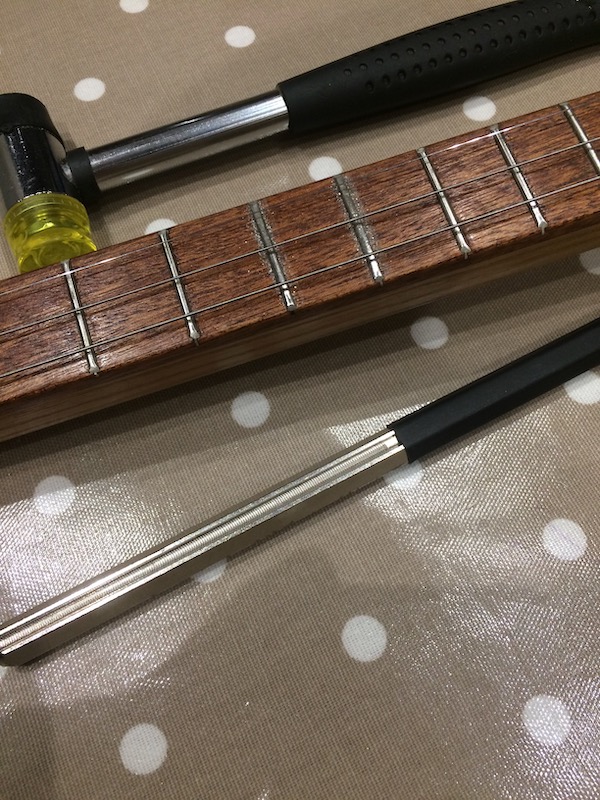 Leveling the frets with the fret file.