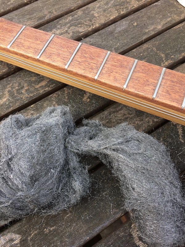 Polishing the frets with wire wool.
